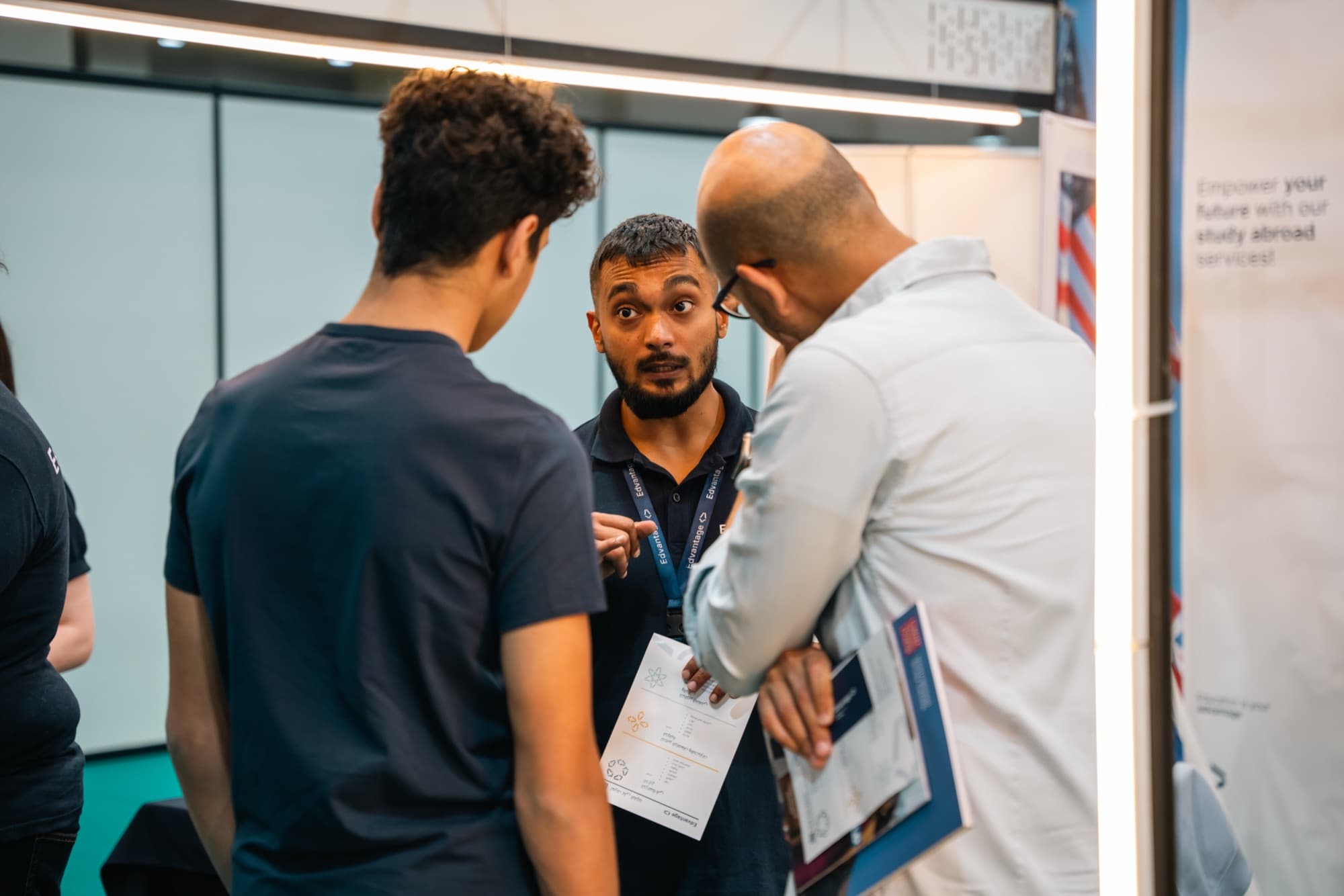 Edvantage advisor guiding a student and parent through study abroad options at an education fair in Kuwait